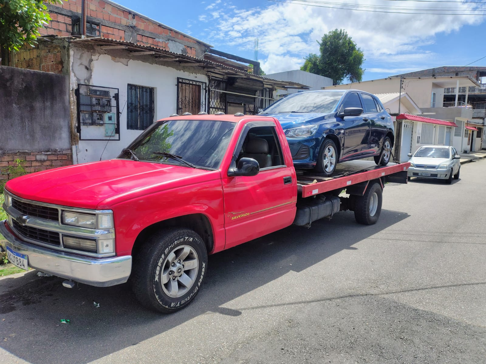 Guincho vermelho transportando carro azul